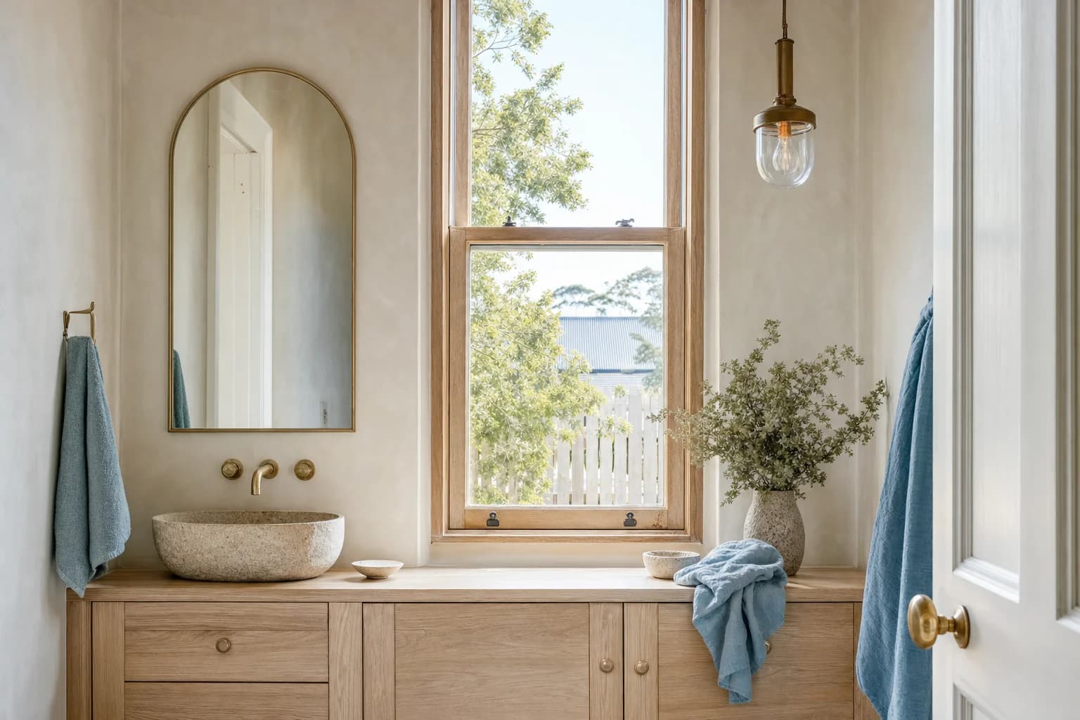 A pale oak vanity under a tall timber sash window in a Bangalow bathroom
