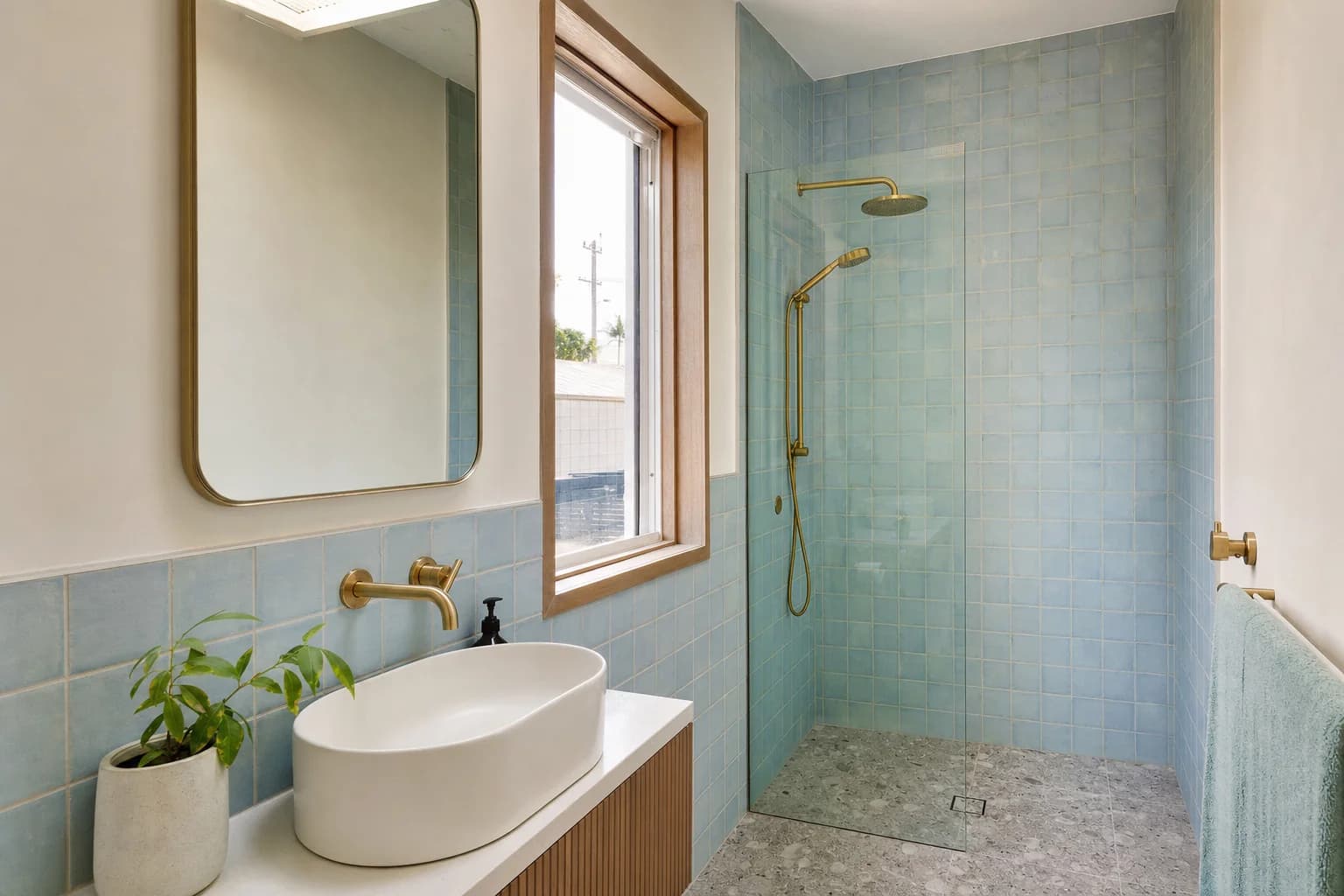 A small renovated bathroom in a Brunswick Heads cottage with sea blue tile and a narrow vanity