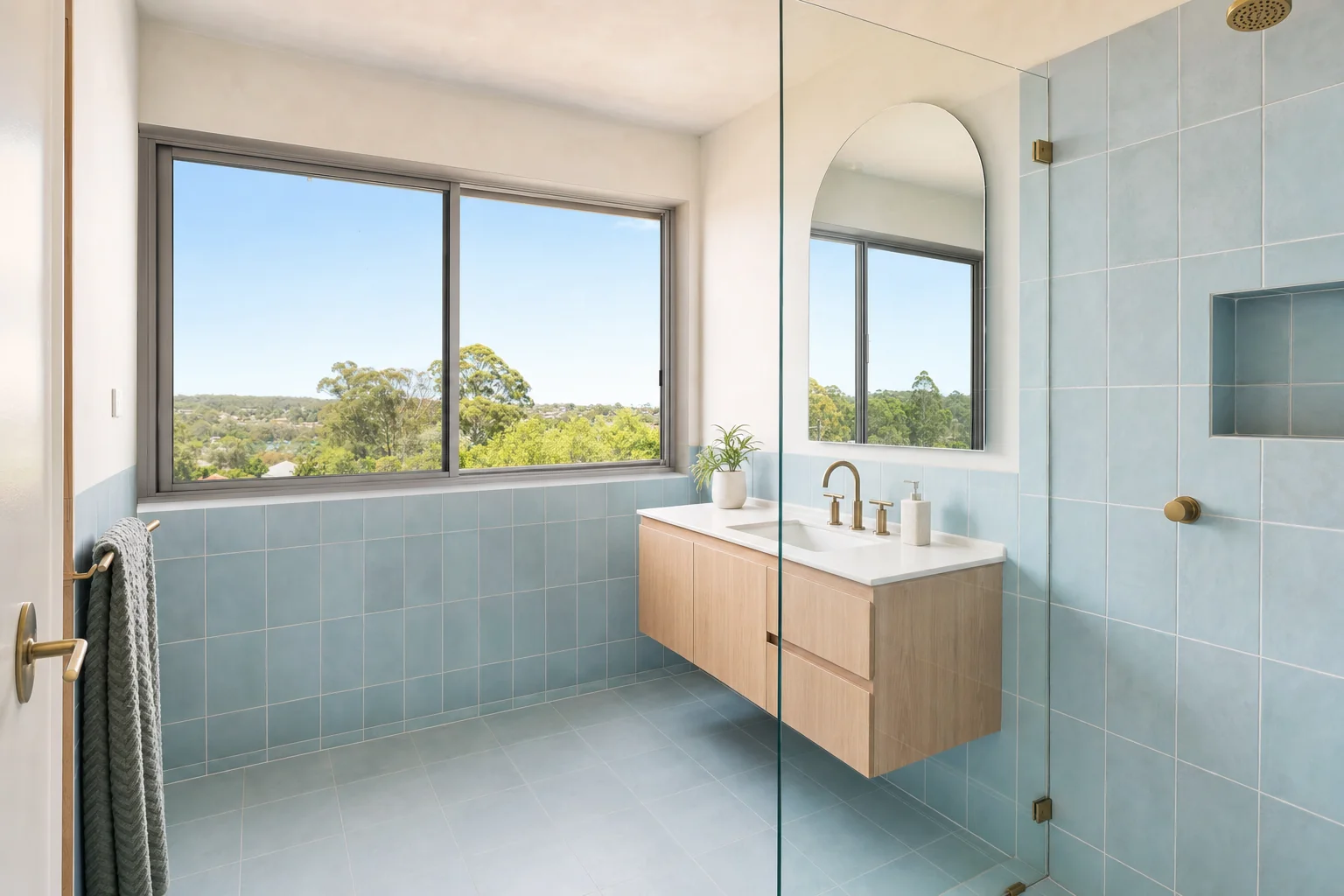 A renovated bathroom in an Ocean Shores split level house with a wide window and sea blue tile