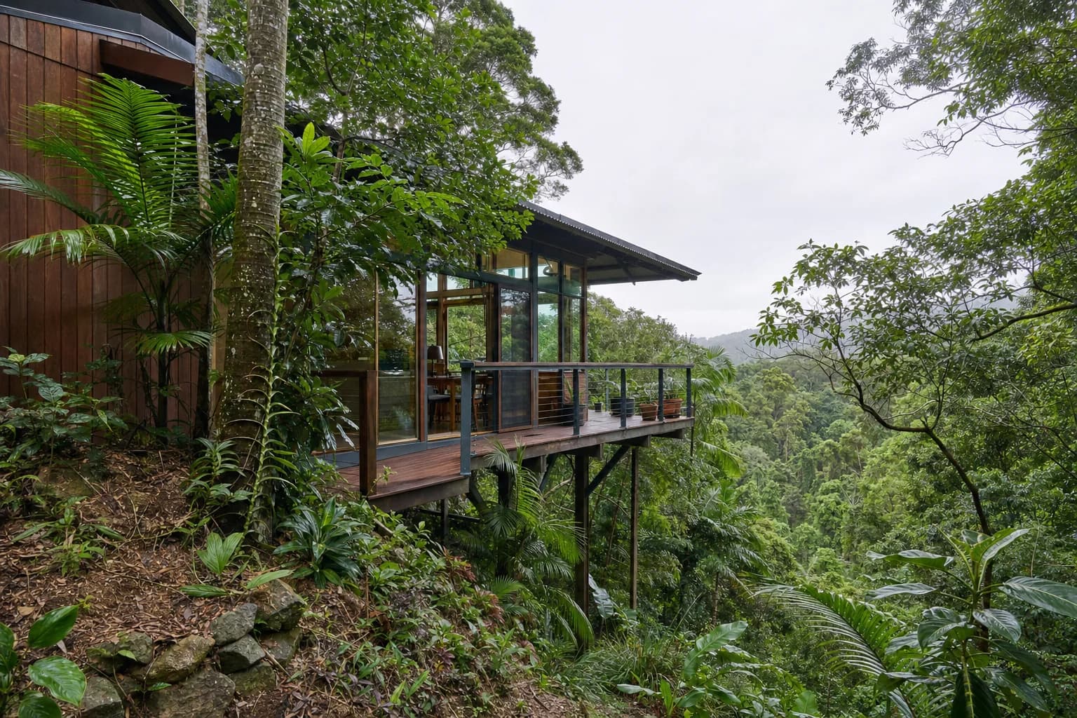 A timber and glass house set into a steep rainforest block at Broken Head