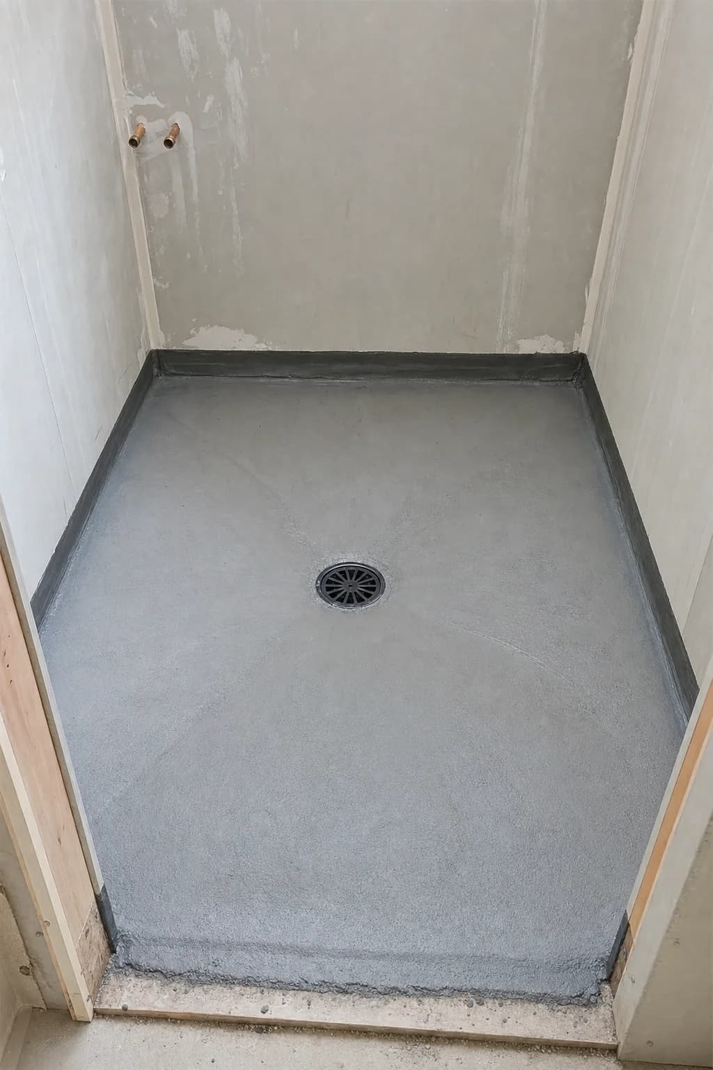 A floor waste grate set into a tiled laundry floor
