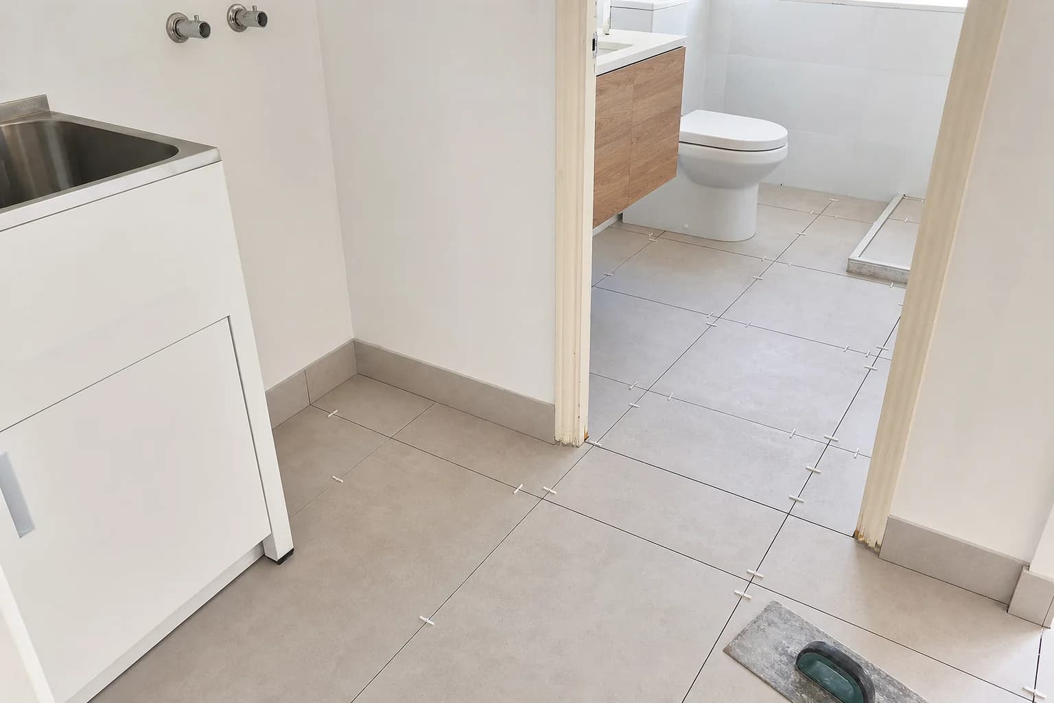 Floor tiling being laid in a wet area