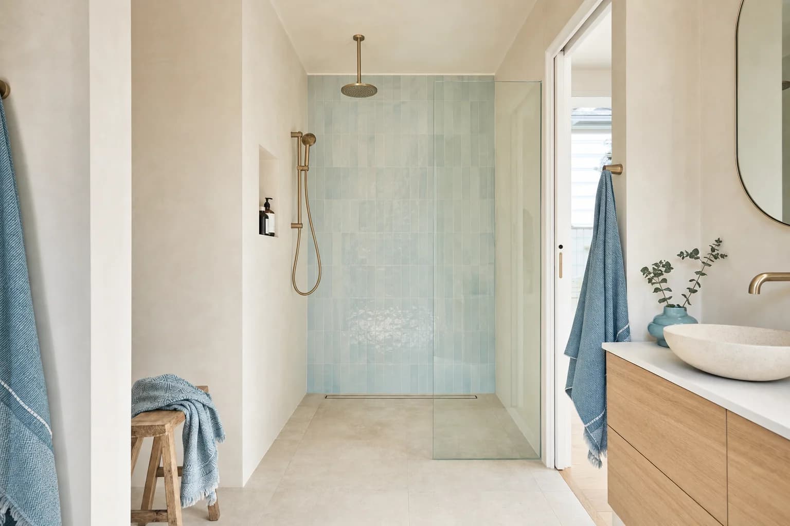 A level entry shower with the floor running through unbroken from the bathroom