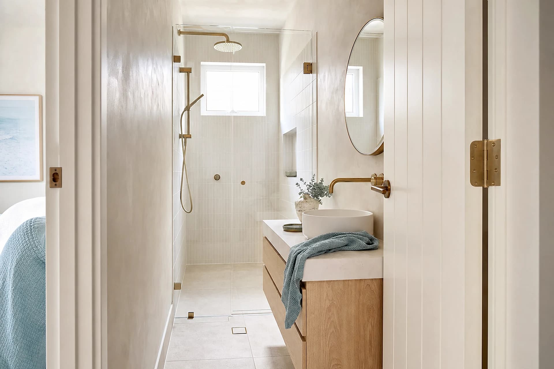 A compact bathroom with a wall hung basin and a level entry shower