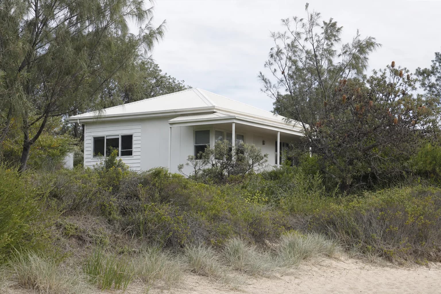 A low set weatherboard beach house behind the dune at Suffolk Park