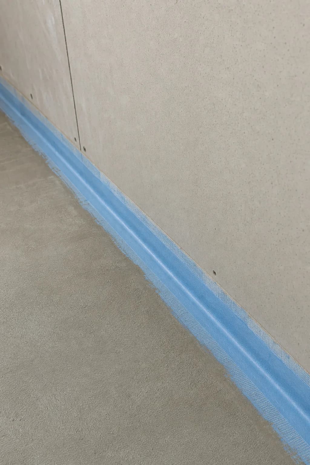 Waterproofing membrane carried up the wall to floor junction of a Byron Bay bathroom in one unbroken band