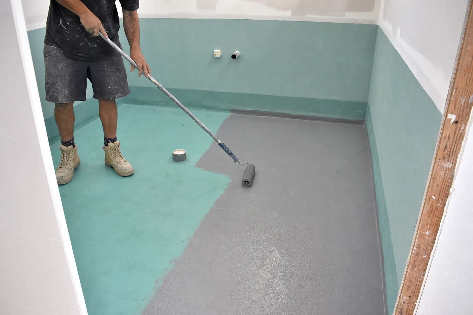 A second coat of waterproofing membrane in a contrasting shade over the first